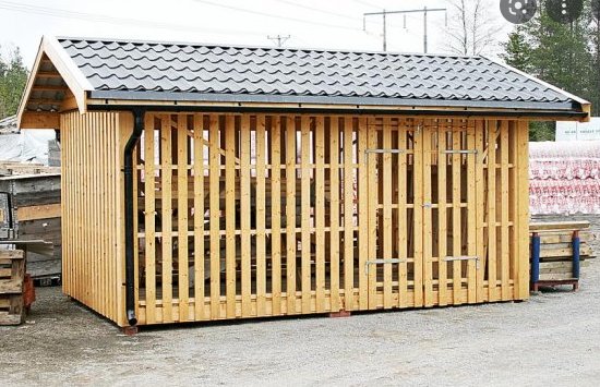 Nybyggd träkonstruktion av en ventilerad förrådsbyggnad utan väggar.
