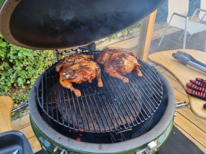 Två grillade kycklingar fyllda med pancetta och örter på grillen.