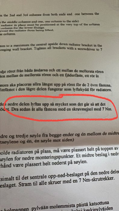 En närbild på en instruktionstext med en markerad mening om att dra åt fästen med 7 Nm.