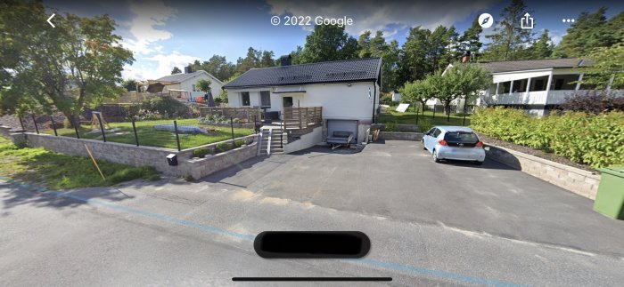 Ett hus med trädgård och parkerad bil synligt från gatan, fångat av Google Street View.