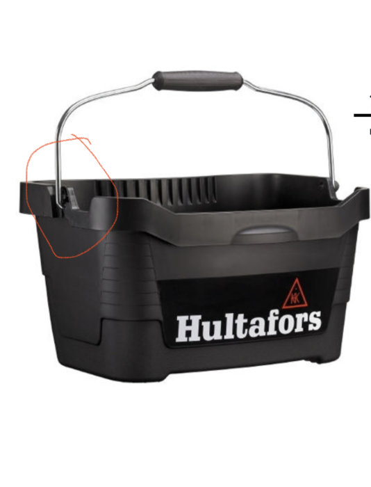 Svart verktygslåda från Hultafors med uppfällt handtag som lutar mot en plastklack.