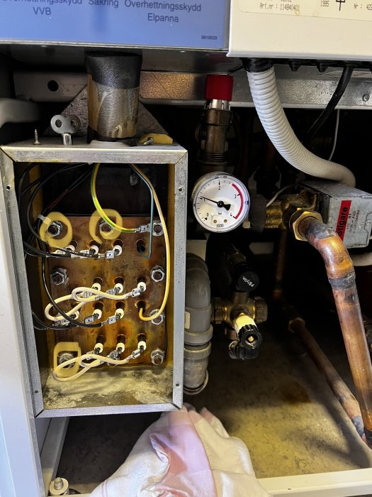 Öppen elpanna med synliga ledningar och röranslutningar, tryckmätare på sidan.