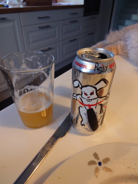 Öppen ölburk från Purity Brewing och halvtömt glas med DIPA på köksbänk.
