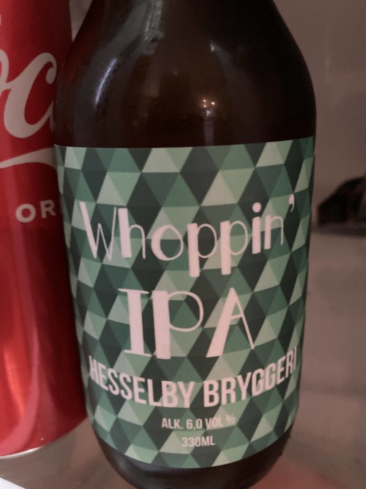 Flaska med etikett för 'Whoppin' IPA' från Hessleby Bryggeri, med alkoholstyrka på 6,0 % och volym på 330 ml.