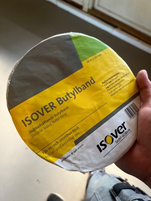 Hand håller en rulle ISOVER Butylband för inomhus- och utomhusbruk vid byggnation.