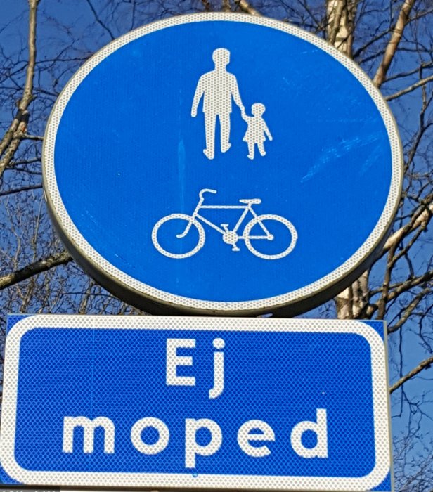Trafikskylt som visar en vuxen med ett barn och en cykel med texten "Ej moped" nedanför.