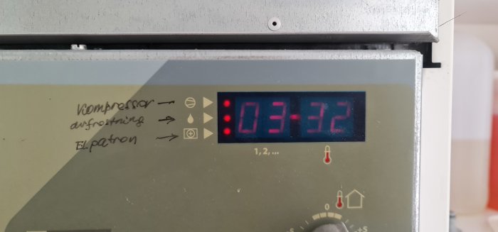 Digital display på en apparat som visar röda siffror 03:32 och flera statusindikatorlampor tända.