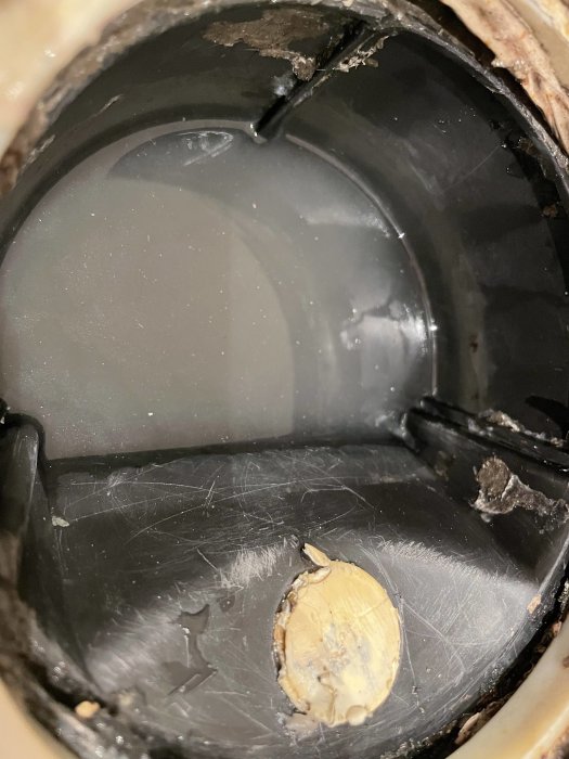 Bild på insidan av ett rör med skador och en ojämn yta med en uppbyggnad av material som blockerar passagen.