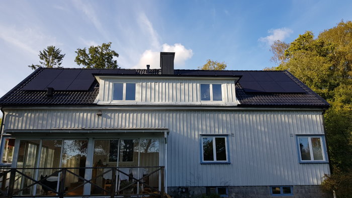 Ett hus med nyligen installerade solpaneler på taket i dagsljus.