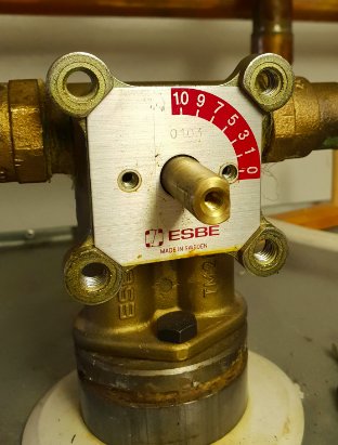 ESBE termostatventil installerad på rörsystem, inställd på värde mellan 1 och 2, med tydlig märkning.
