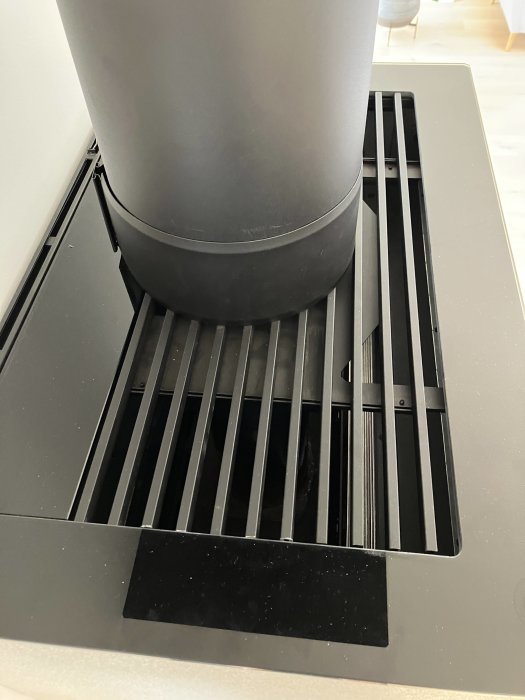 Ventilationsgaller i kök med synlig del av en kamin, indikerar problem med doft vid uppvärmning.