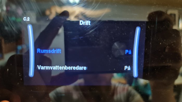 Digital skärmvisning av en uppvärmningspannas status med 'Rumsdrift' och 'Varmvattenberedare' inställningar på 'På'.