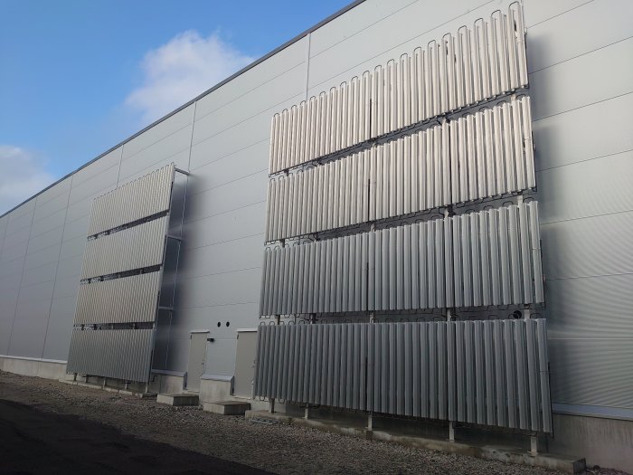 Stora industriella solavskärmningar monterade på en väggyta utomhus.