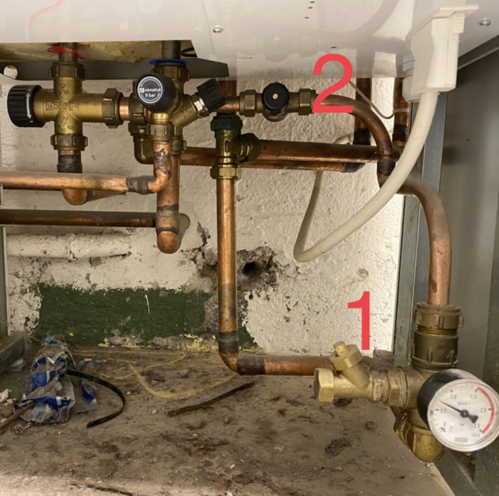 VVS-installation med manometer märkt '1' och påfyllningsventil märkt '2' för radiatorkretsen.