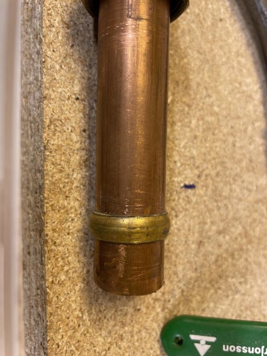 Kopparrör med nyinstallerad klämkoppling monterad nära en gammal lödning.