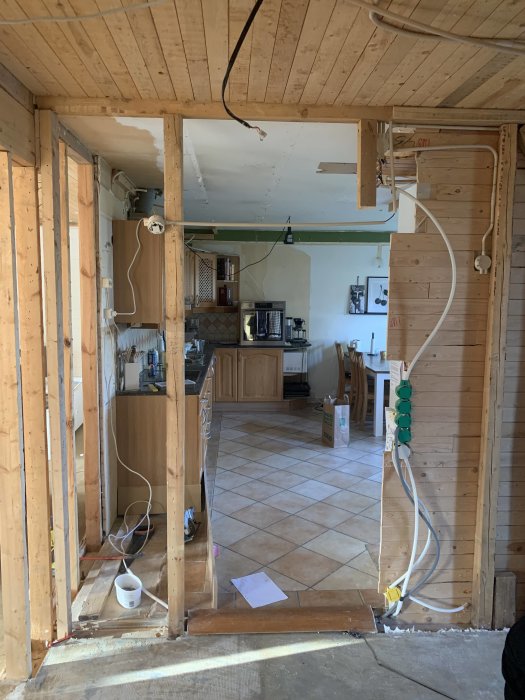 Renovering av kök med öppen väggstomme och synlig elektrik.