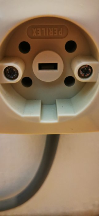 Närbild på en ojordad vägguttag med en USB-port.