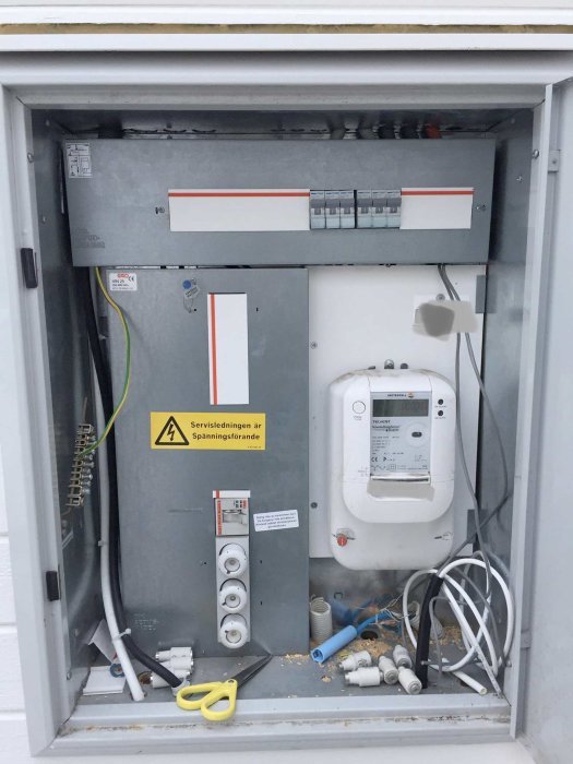 Elektriskt skåp med säkringar och mätare, öppnat för uppgradering från 25A till 50A.