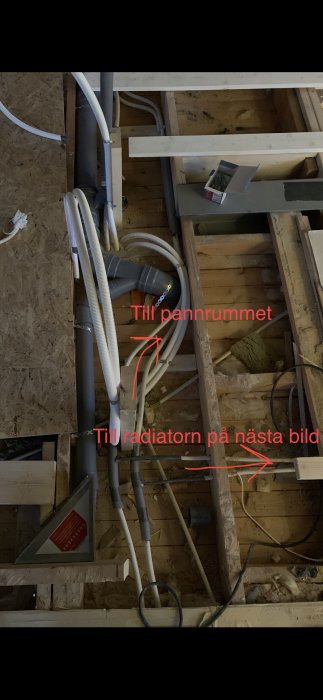 Rörledningar och elkablar i tak med text som visar riktning till pannrum och radiator.