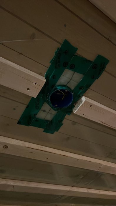 Nyinstallerad takdosa med elslangar i takstomme, säkrad med grön tejp.