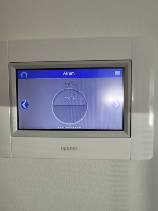 Digital termostat på vägg med display som visar 'Allrum' och tomma temperaturindikatorer, märkt 'uponor'.