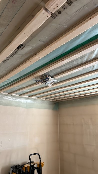 Tak med träreglar och isolering, nya elektriska takdosor monterade, saknas gipshiss.
