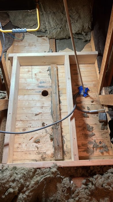 Nyinstallerad vindslucka i takkonstruktion, omgiven av isoleringsmaterial och träramar.