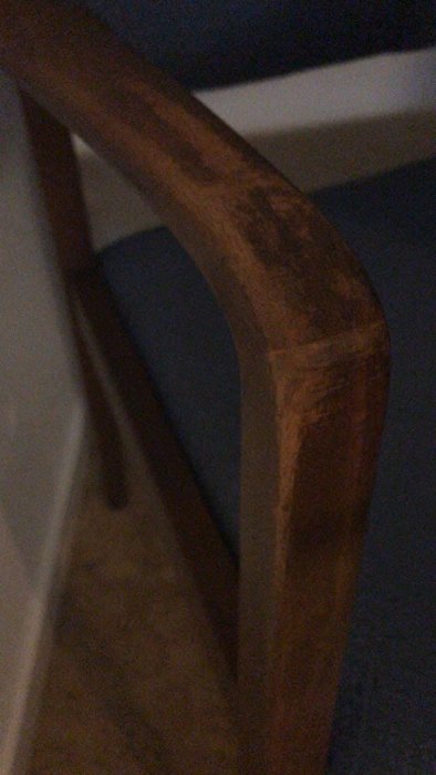 Närbild på ovansidan av en trästol med synliga åldringsmärken och slitage.