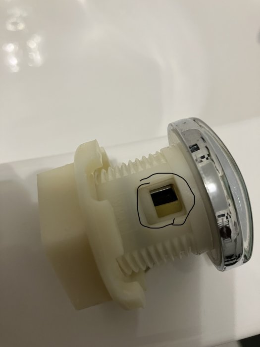 Ersättningsvred för luftintag på badrumsspa, delvis i plast och metall, liggande på vit yta.