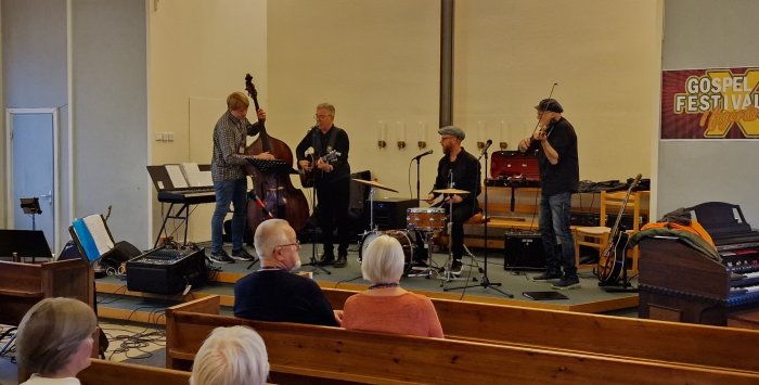 Musiker uppträder på en gospel festival i en kyrka med publik i förgrunden.