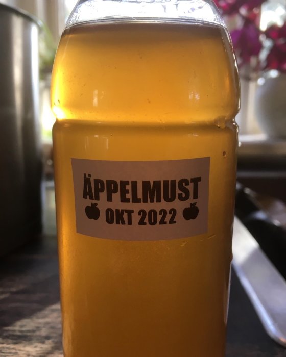 En flaska hemgjord äppelmust märkt med "OKT 2022".