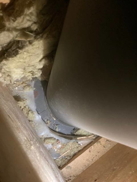Närbild på ett ventilationsrör som passerar genom isolering i en vägg.