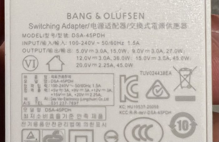 Specifikationsetikett på en Bang & Olufsen-switchingadapter med modellinformation och varningssymboler.