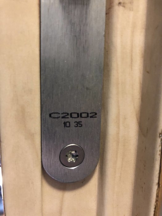 Befintligt lås på en dörrkarm med modellbeteckningen C2002 och mått 10 35 synligt på låsblecket.