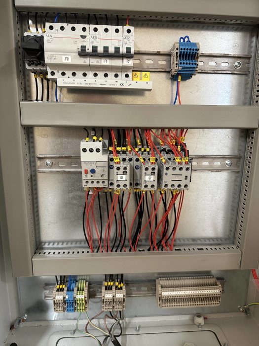 Öppet styrskåp med kablage och komponenter för Y/D-start av elmotor, inklusive kontaktorer och säkringar.