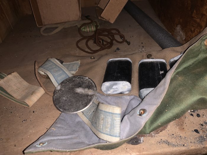 Dammpartiklar på ett par använda arbetsbälten och skyddsglasögon liggande på en byggarbetsplats.