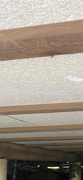 Stödbjälkar och isolering i taket på ett pågående byggprojekt.