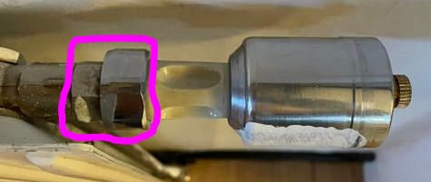 En bild av ett äldre AG/TP-koppel med en markerad mutter och en adapter före termostaten.