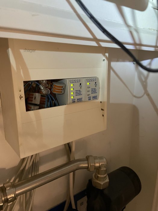 Elcentral öppen med synliga brytare och kopplingsutrustning, rör i förgrunden.