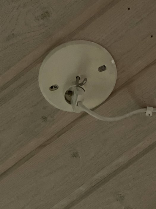 Takkoppling med kablar och osäker fästanordning mot träpanel.