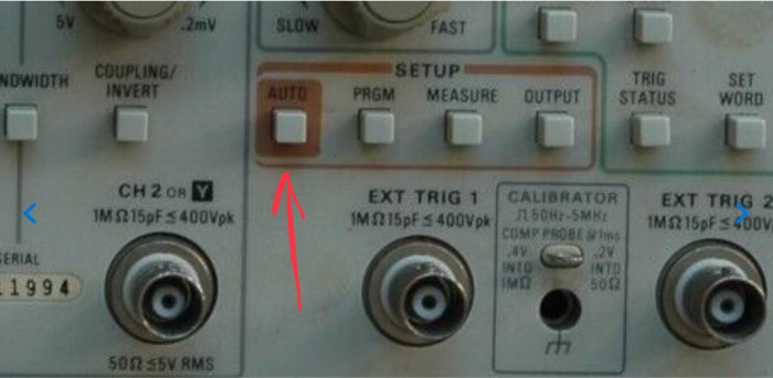 Närbild på en Tektronix analog oscilloskopets frontpanel med knappar och inställningsrattar.