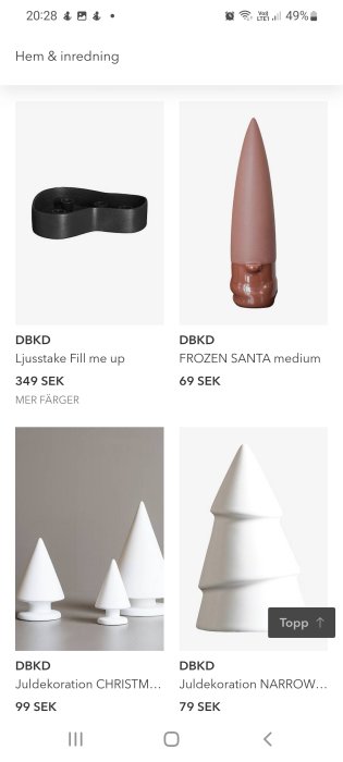 Modern juldekorationer: svart ljusstake, rosa "Frozen Santa" och vita geometriska trädfigurer.