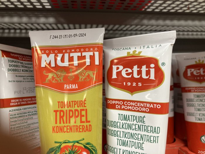 Tomatpuréförpackningar från Mutti och Petti i en butikshylla.