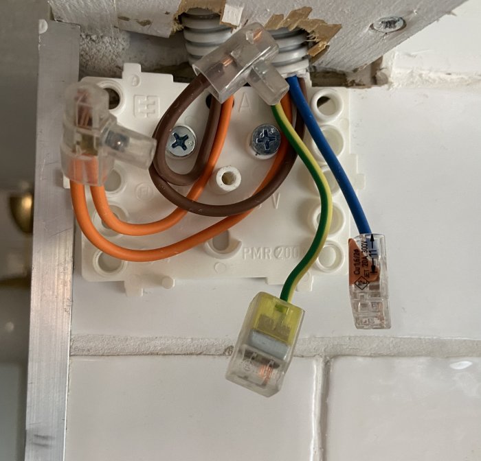 Eluttag under installation med osäkrade kablar och skruvanslutningar synliga.