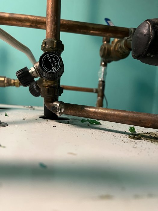 Kopparledningar med ventil och skruvbart reglage, eventuellt läckage syns vid anslutning.