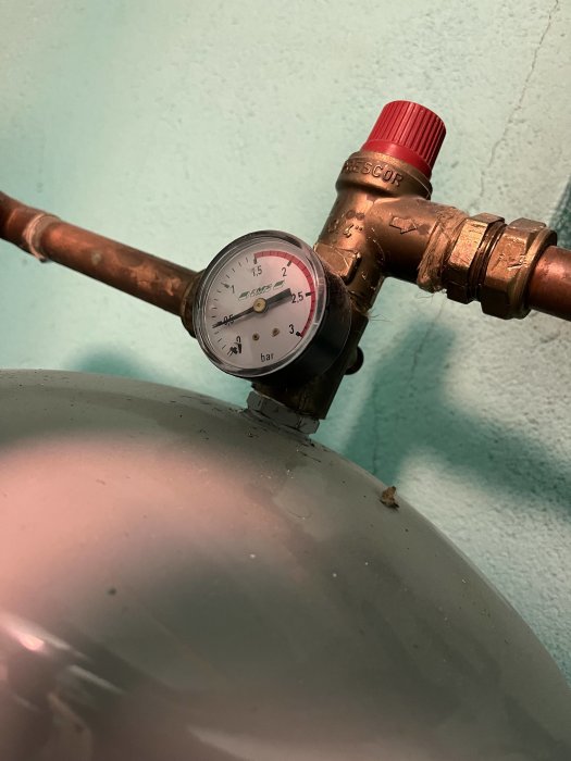 Tryckmätare visar ökat tryck i en kopparledning kopplad till en pump.