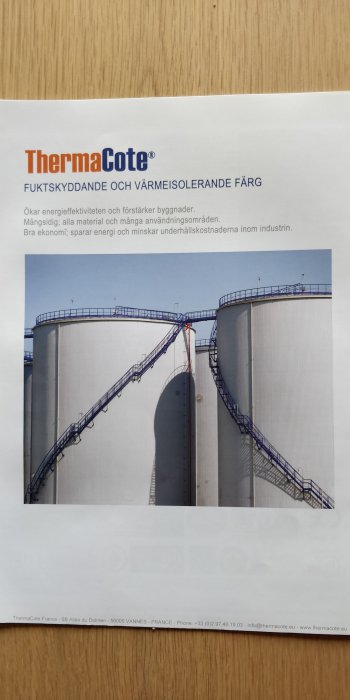 Två industriella silos med en förbindande trappa, marknadsföring av färgprodukten ThermaCote.