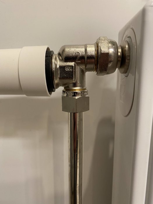 Rörkoppling i vägg med siffra 2 på metallkomponent som en del av en eventuell provisorisk lösning.