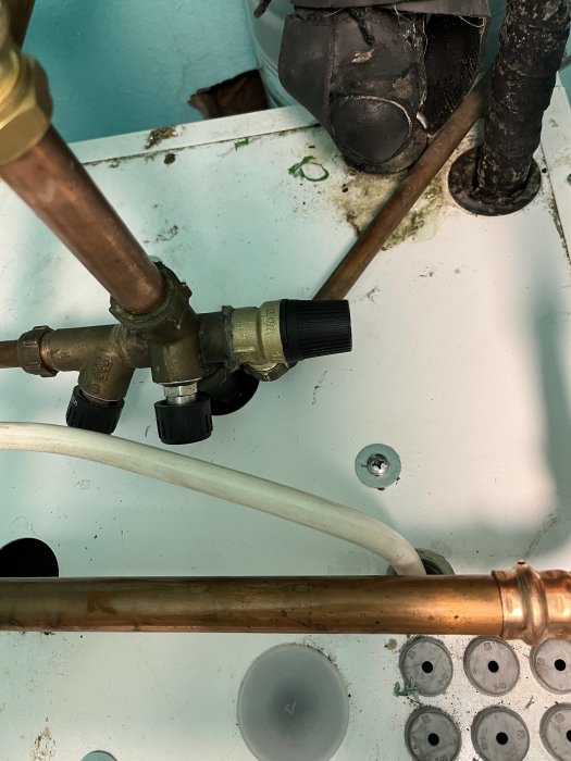 Närbild av nyinstallerad säkerhetsventil på kallvattenrör med verktyg och rördelar.