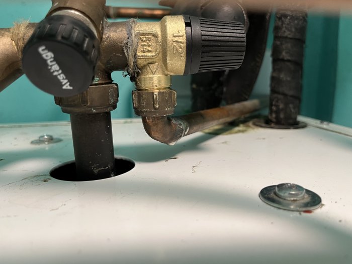 Närbild av en nyligen installerad säkerhetsventil med lin och packningspasta på kallvattenrör.